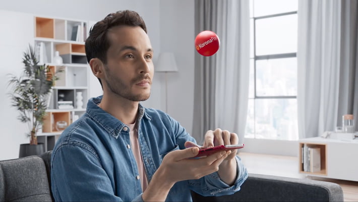 Korona pay | man looking how a red ball gets off the phone